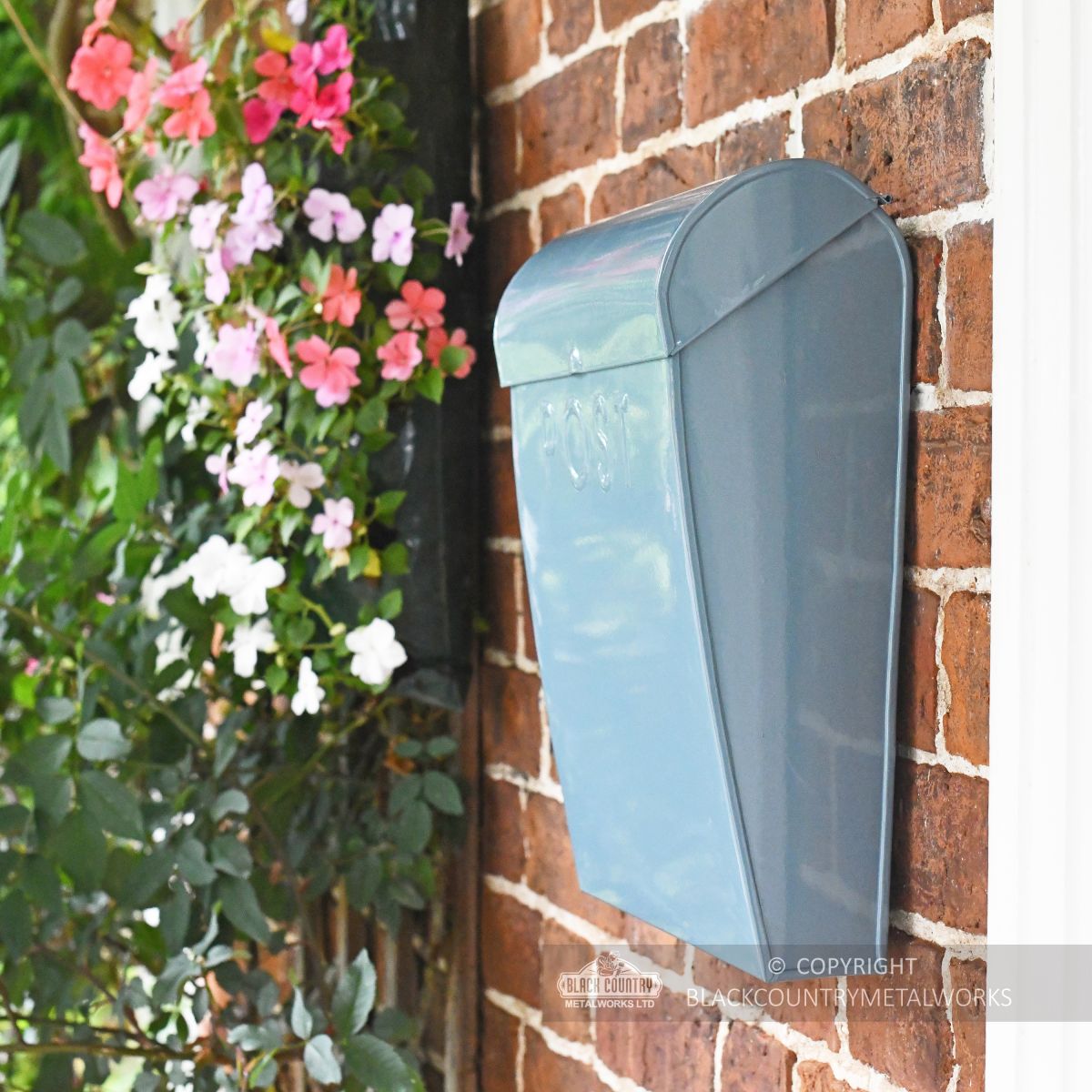 Modern letter box on wall in garden