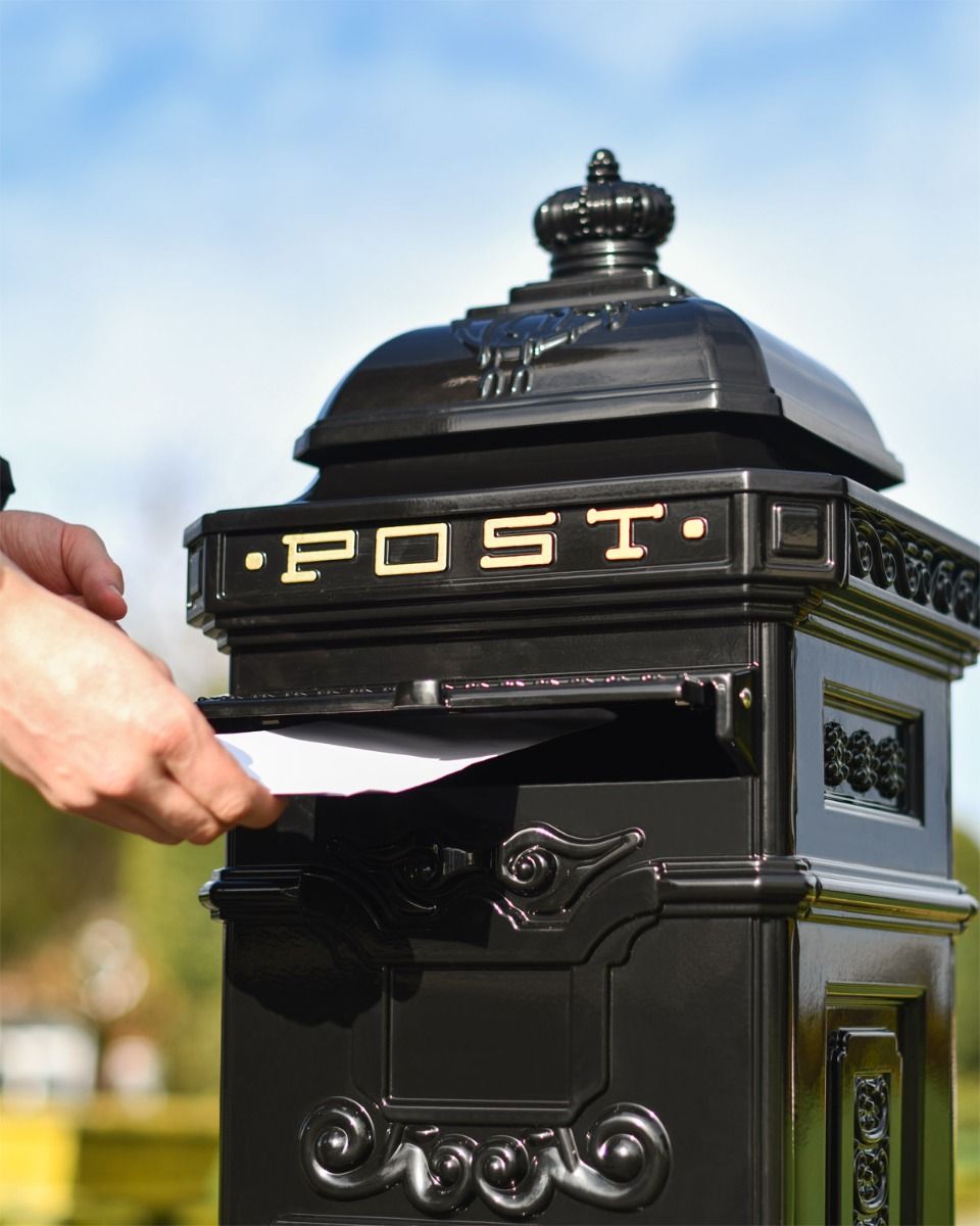 Black Post Box With Letter Being Posted 
