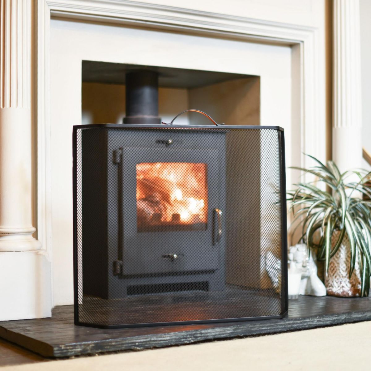 Black Contemporary Curved Fire Guard with Handle In A Fireplace Setting