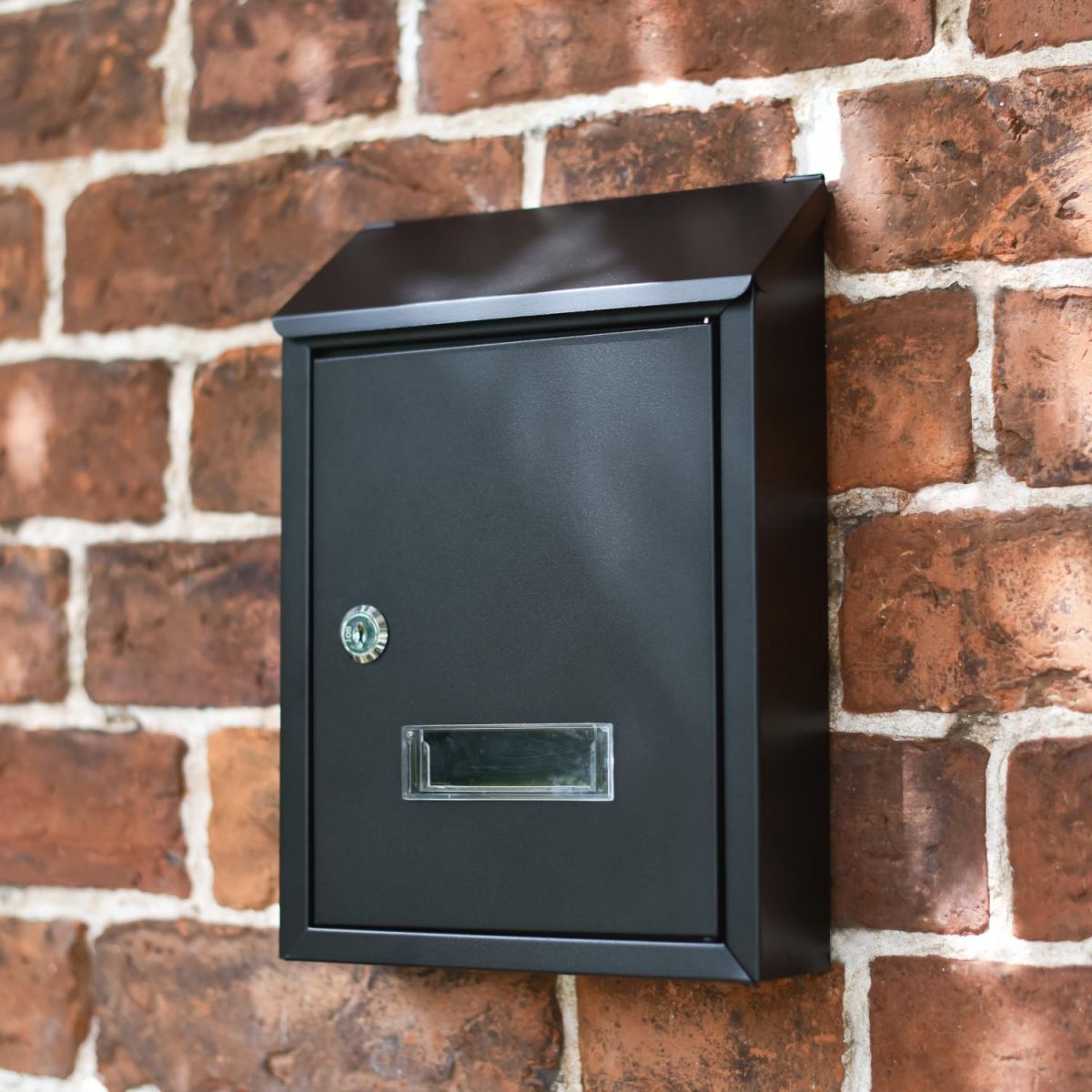 Black Steel Lockable Wall Mounted Post Box in Situ on a Brick Wall