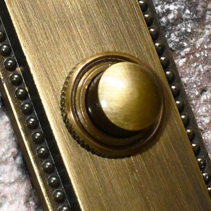 Close up of antique brass Georgian door bell button