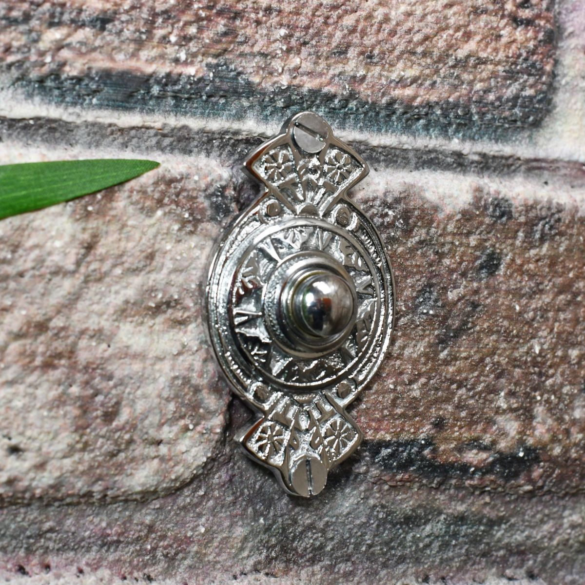 Chrome Classical Ornate door Bell Push on brick wall