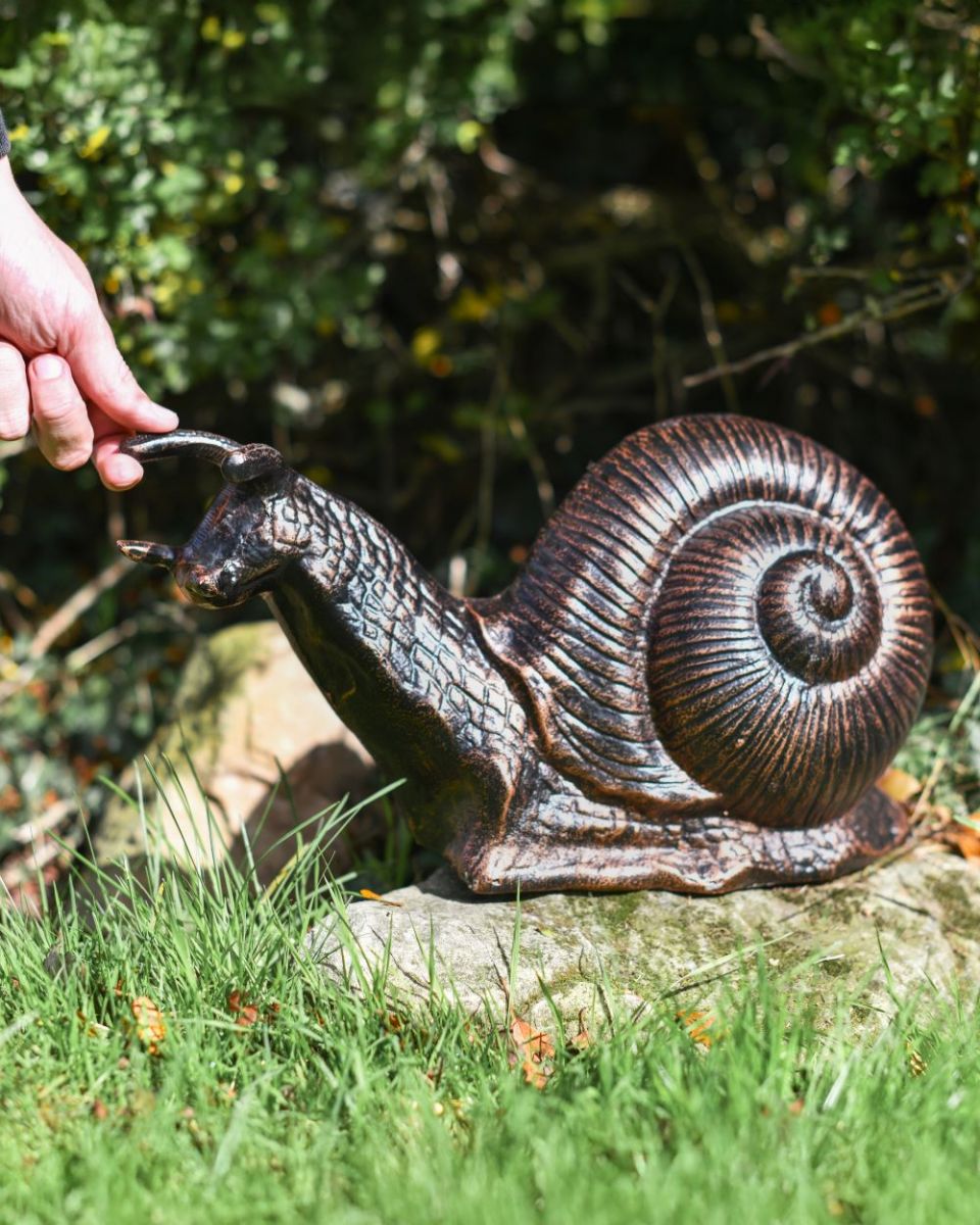 Bronze and Copper snail with hand for scale