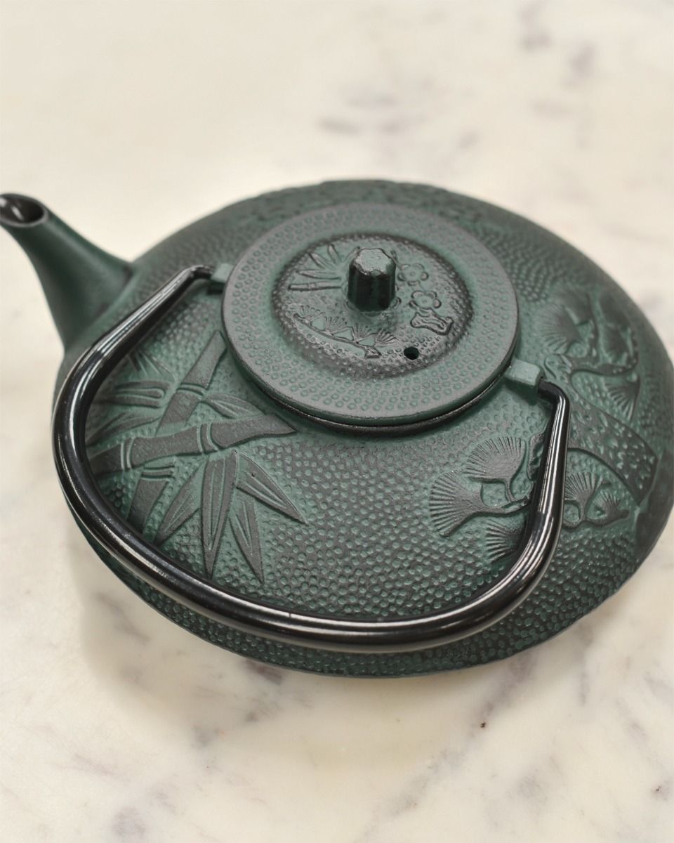 Dark Green Cast Iron Teapot With Handle Down and Lid On 