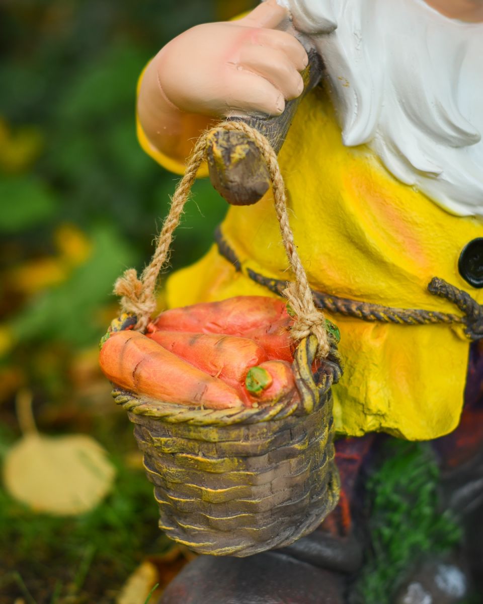 Close up of carrot basket detail on colourful outdoor gnome sculpture Close up of carrot basket detail on colourful outdoor gnome sculpture