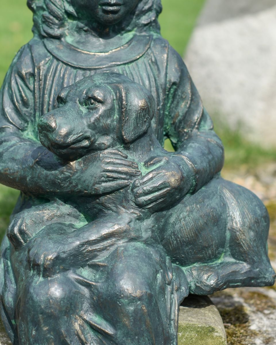 Close up of intricate dog detail on garden wall statue