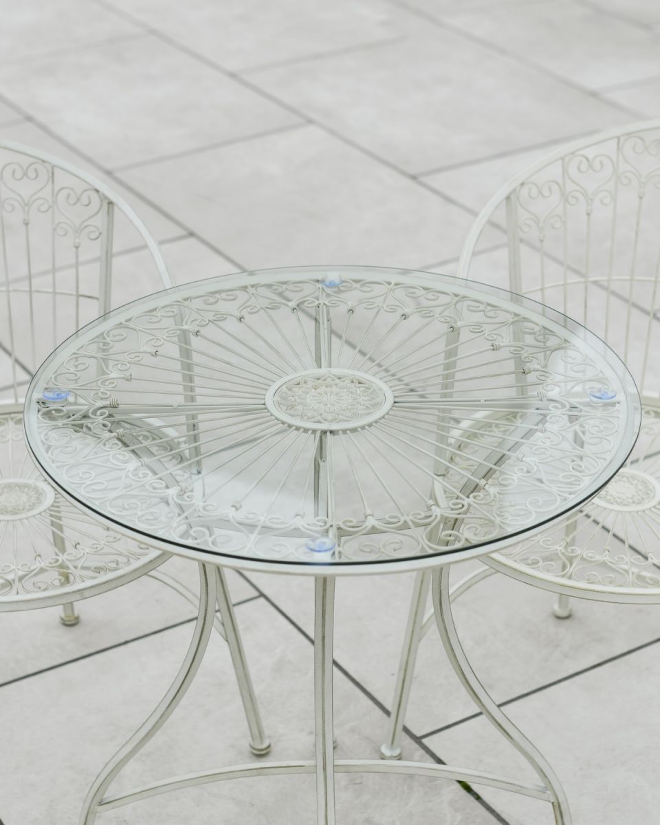Close up of glass table top detail on outdoor two seater table and chairs set