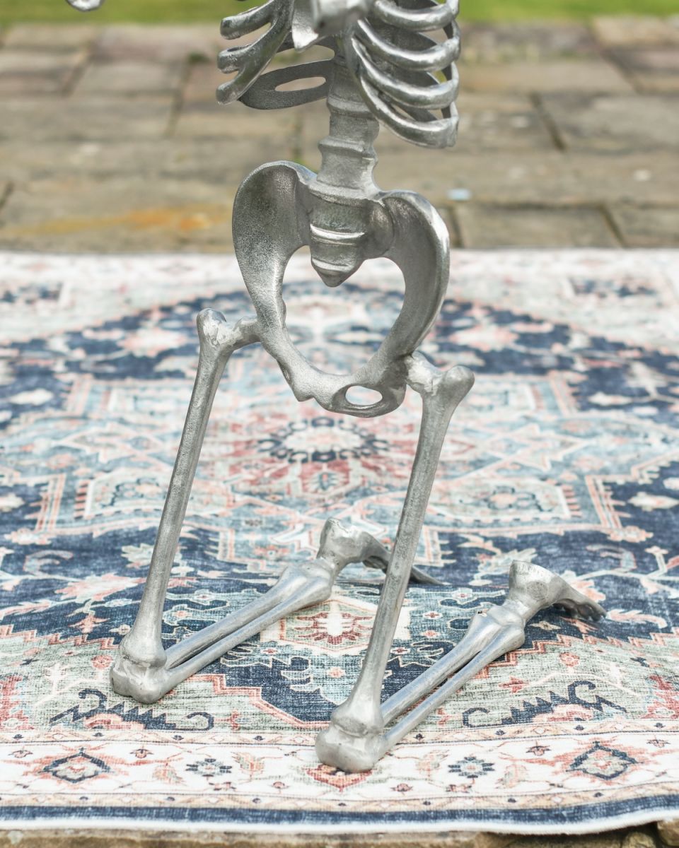 Close up of intricate kneeling legs detail on outdoor skeleton statue