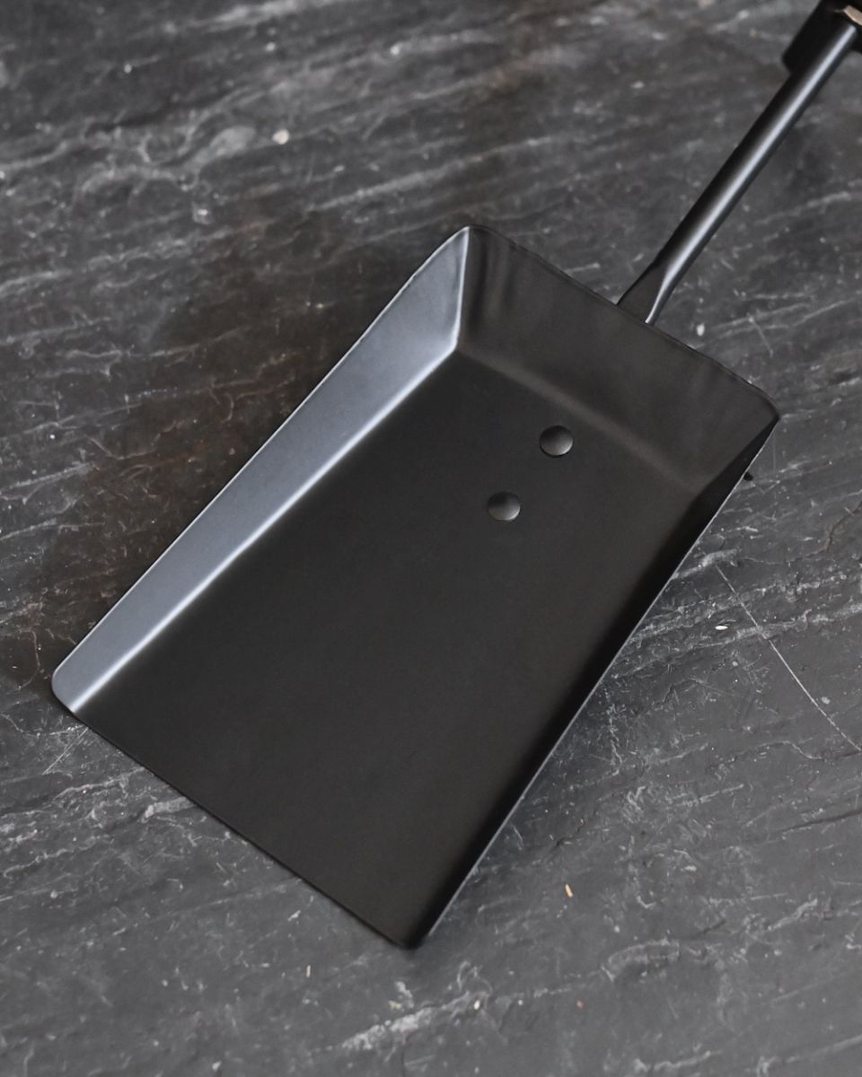 Close up of shovel in fireside brush and shovel set