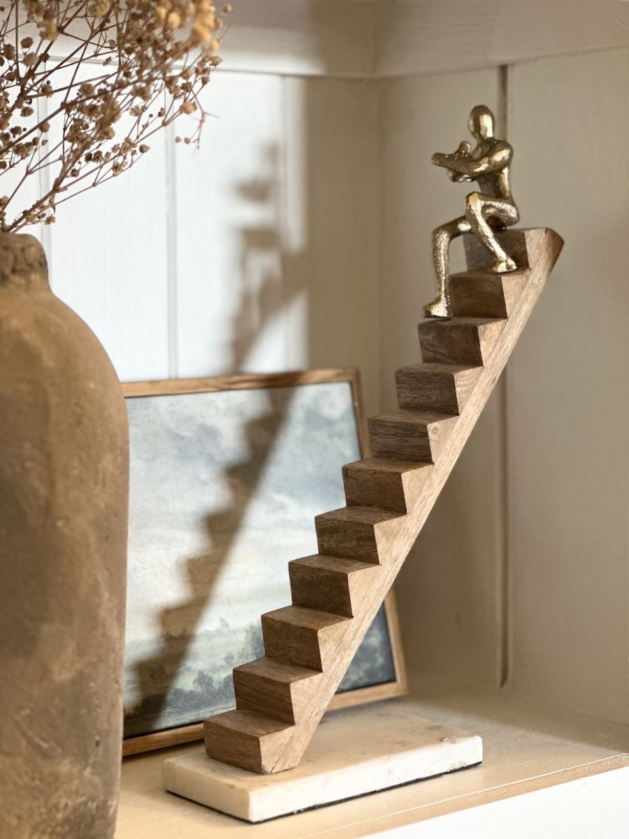 Angled view of intricate detail on gold figure home decor accessory