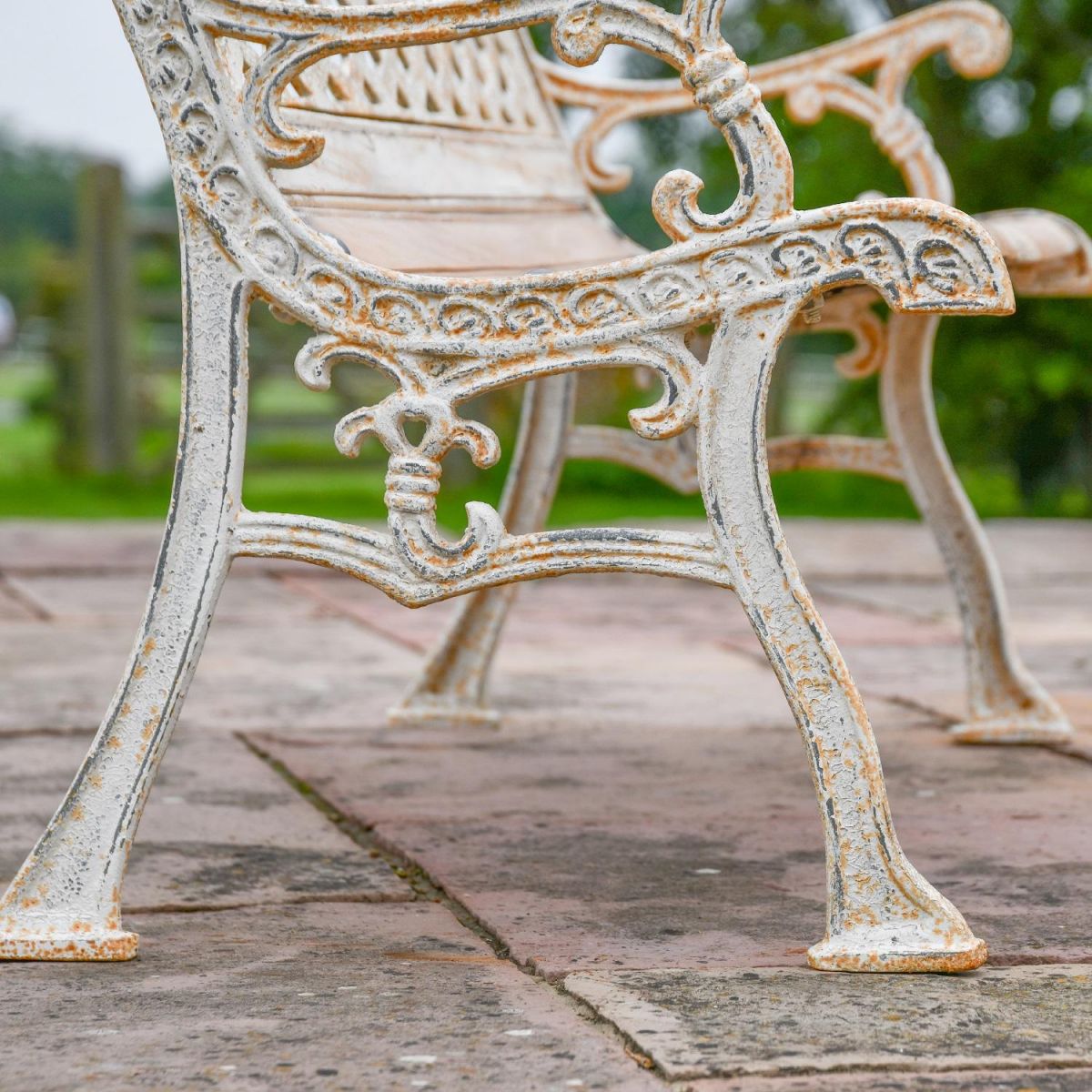 Close up of Antique Cream Cast Iron Bench Legs with scroll detailing