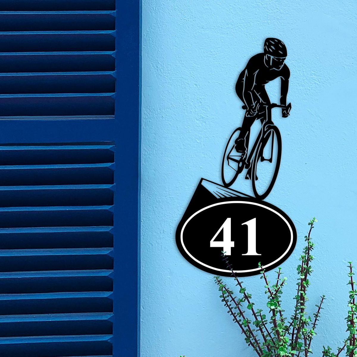 Cyclist Iron House Number Sign on a Blue Wall