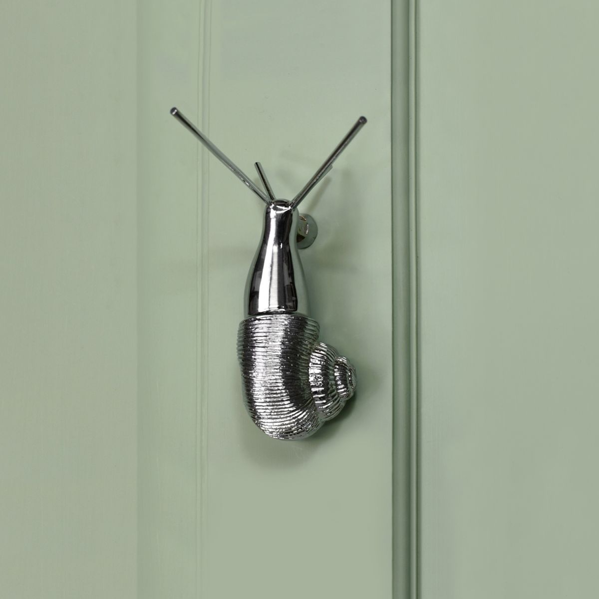 Bright Chrome Snail Door Knocker on Green Door