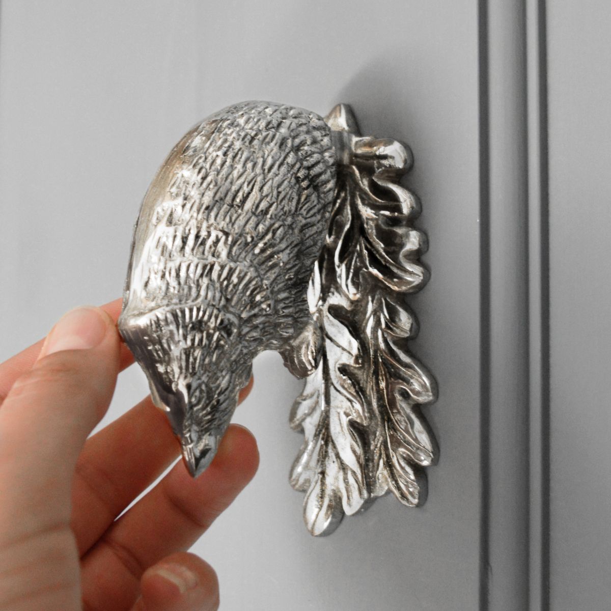 Bright Chrome Hedgehog door knocker on grey door scale image