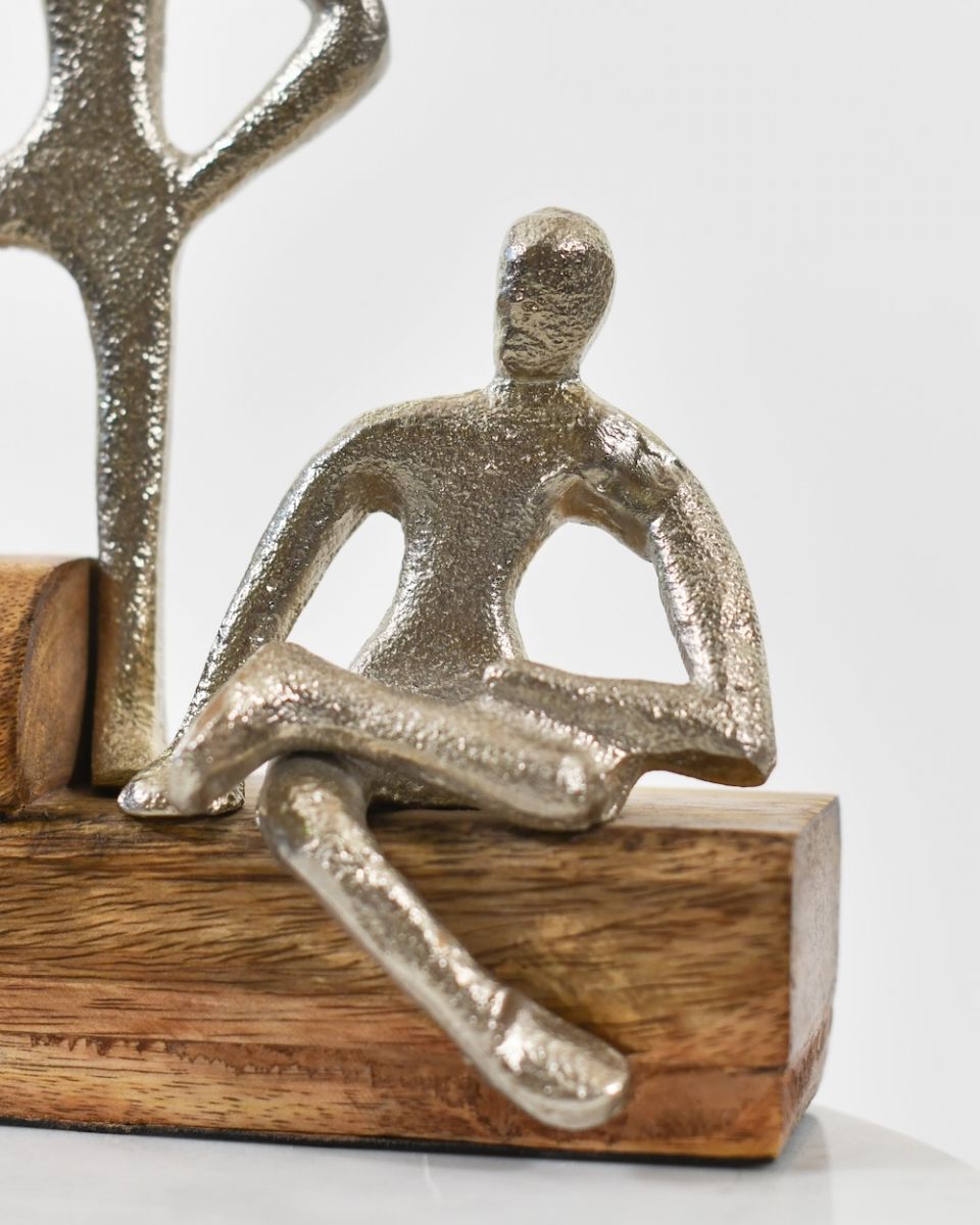 Close up of cast aluminium figure on a mango wood base interior art sculpture