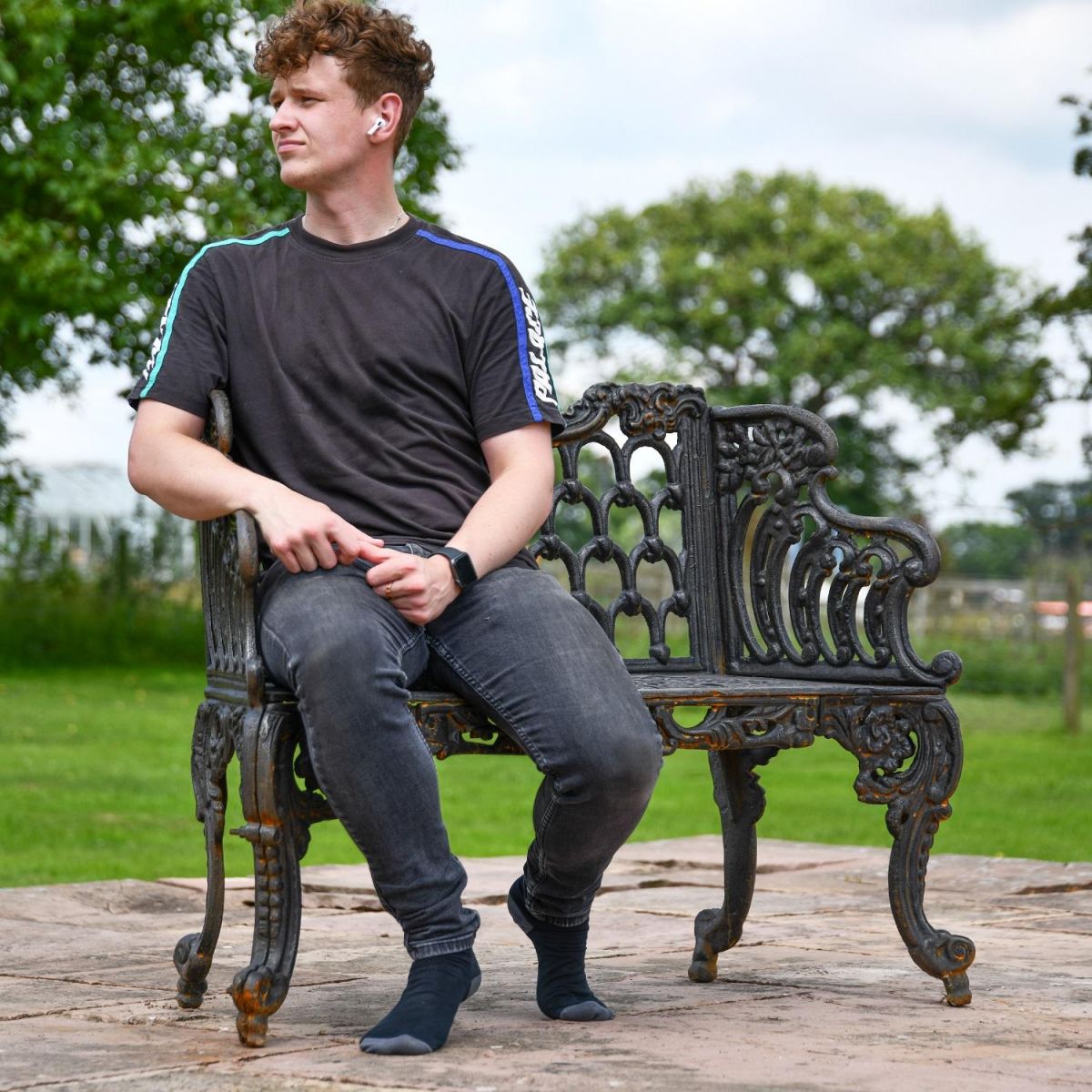 Ornate Black Ornate Cast Iron Bench with Male for scale 
