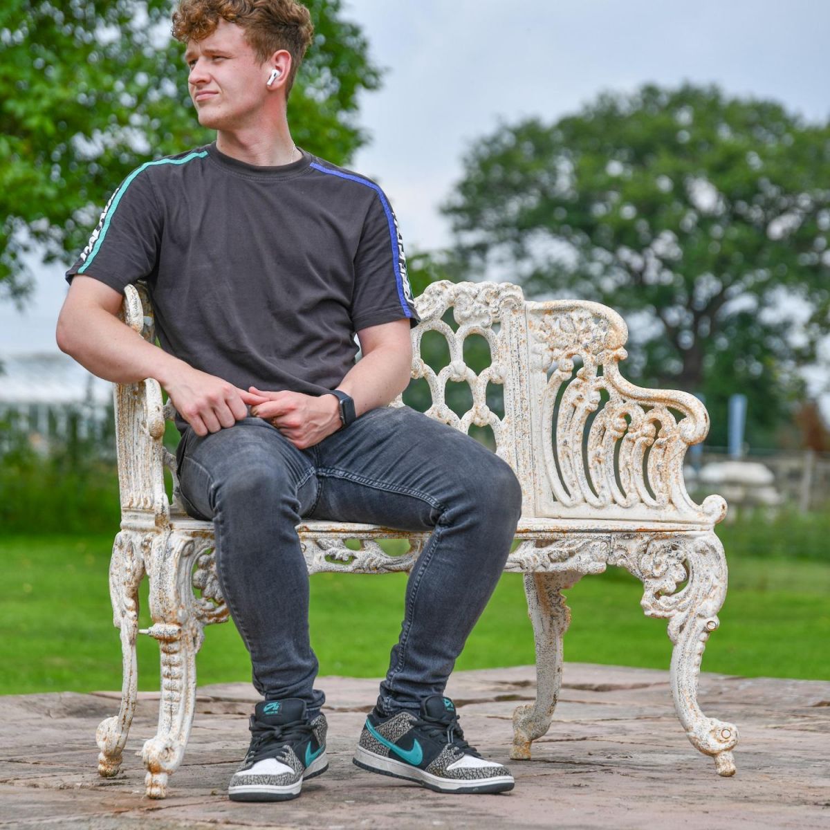 Male sat on Antique Cream Ornate Garden Bench for Scale