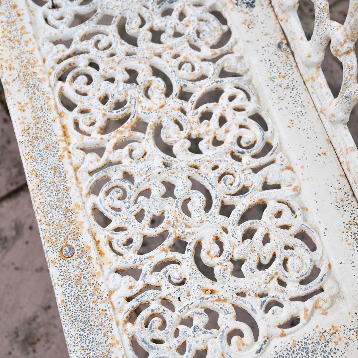 Close up of ornate design on Antique Cream Cast Iron Bench