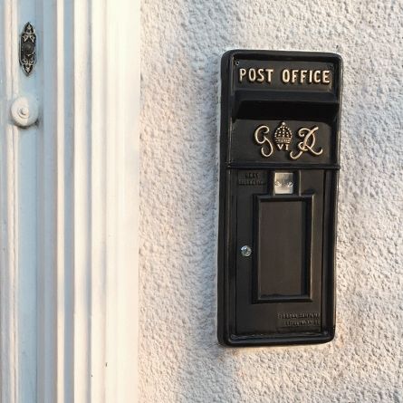 King George rex post box front on house wall by door
