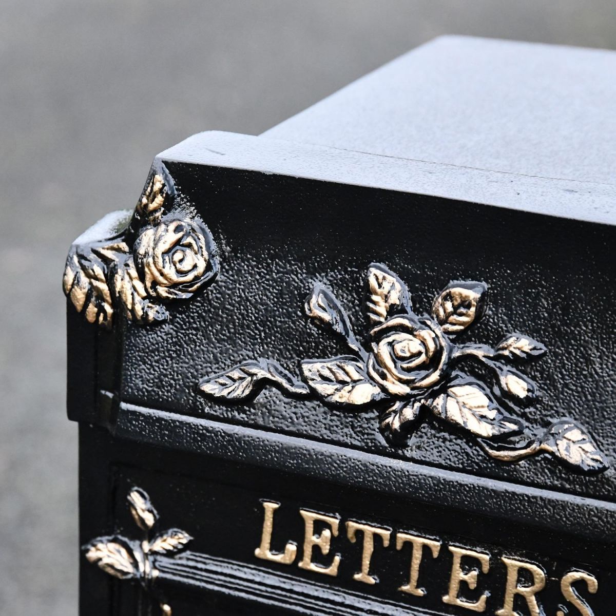 Close up of floral and rose detailing on post box 