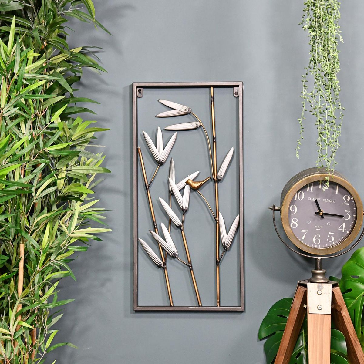 Metal Bamboo Metal Wall Art in Situ Next to Plants and a Floor standing Clock