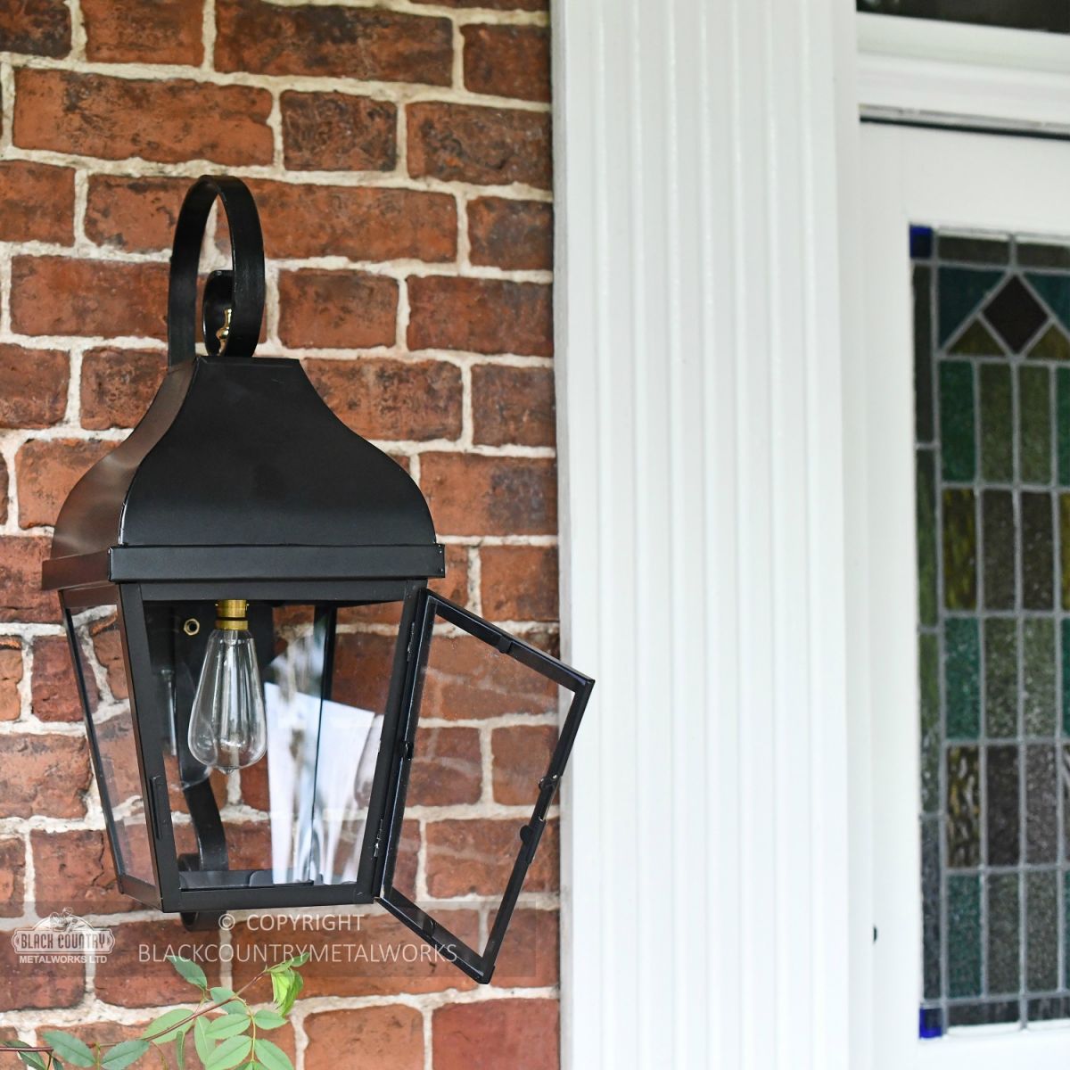 Midnight Black Flush Wall Lantern With Scrolled Bracket In Porch Setting