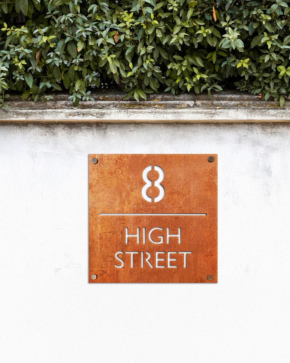 Modern Square Corten Steel House Number Sign in Situ on a White Garden Wall