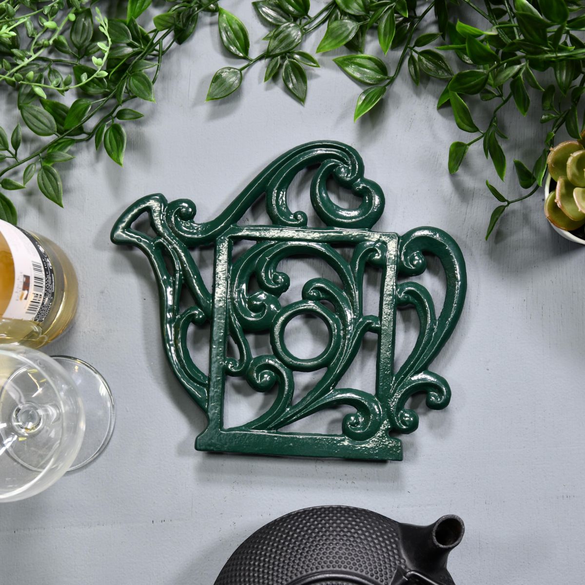 Green Cast Iron Kettle Trivet on Blue Table