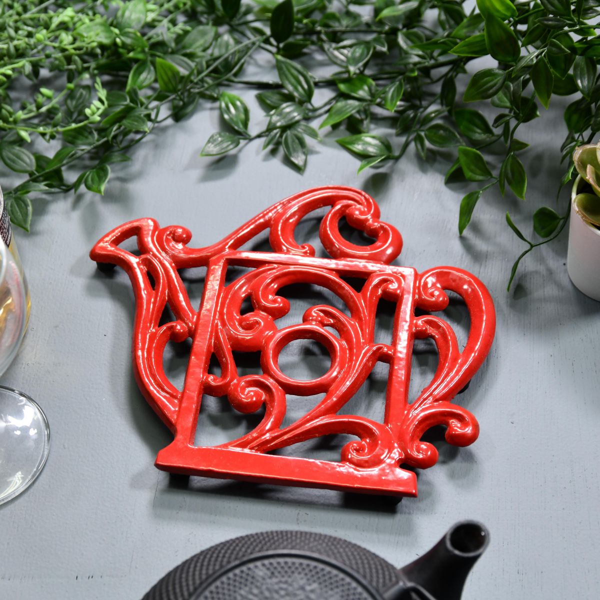 Red Cast Iron Kettle Trivet in Situ on Blue Table