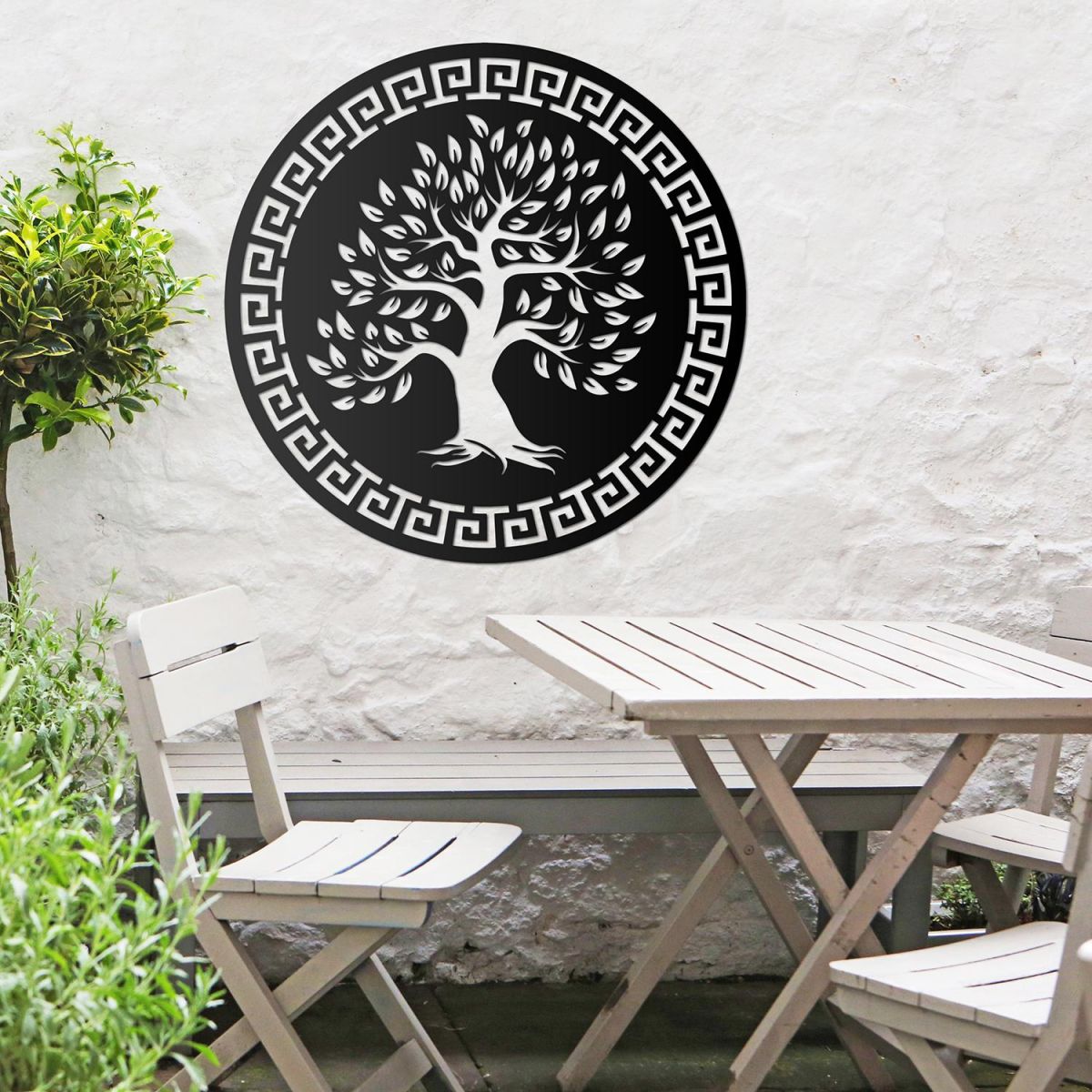 Round "Olive Tree" Wall Art in the Garden Above a Wooden Table and Chair Set