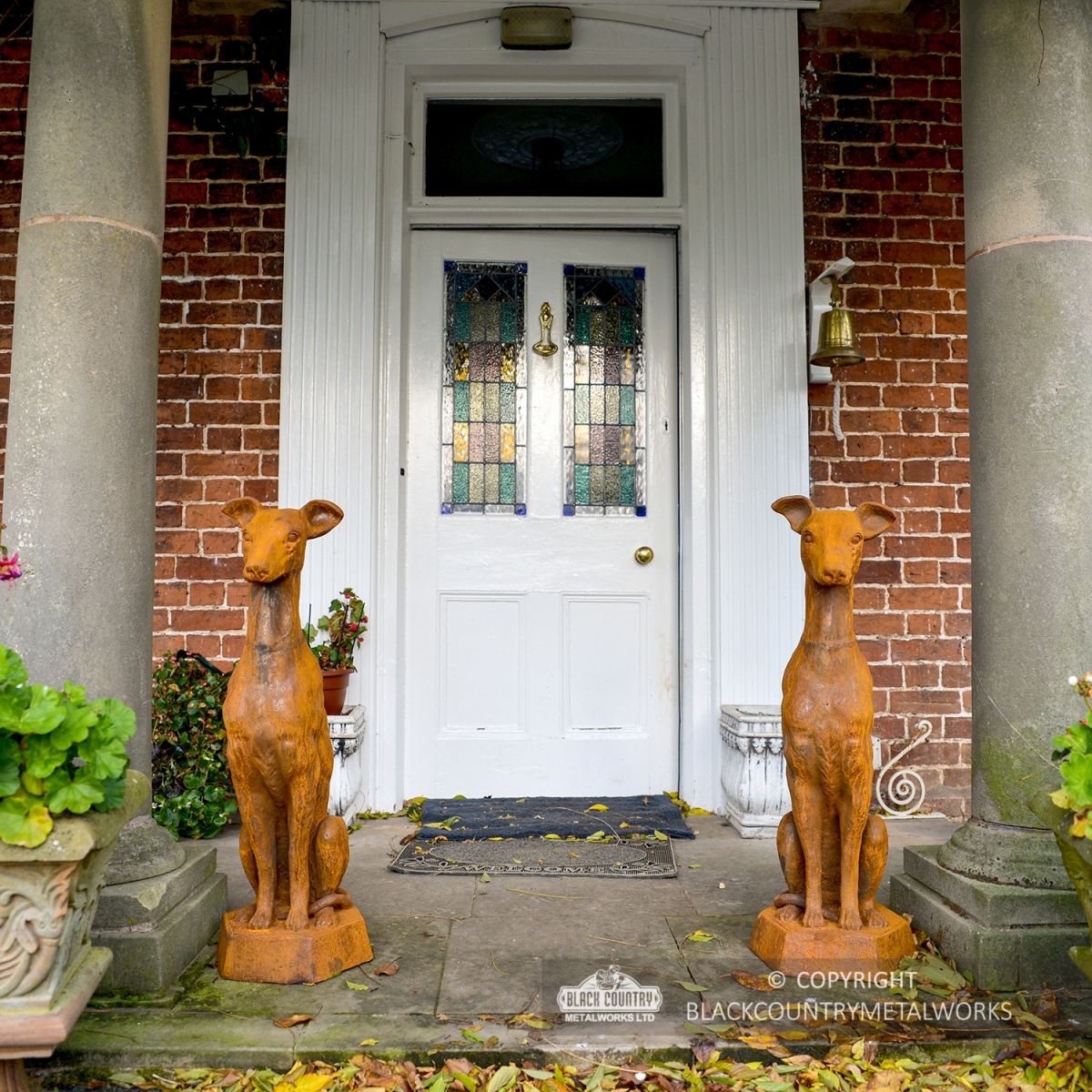 Pair of Cast Iron Greyhound Sculptures Sitting Outside a House