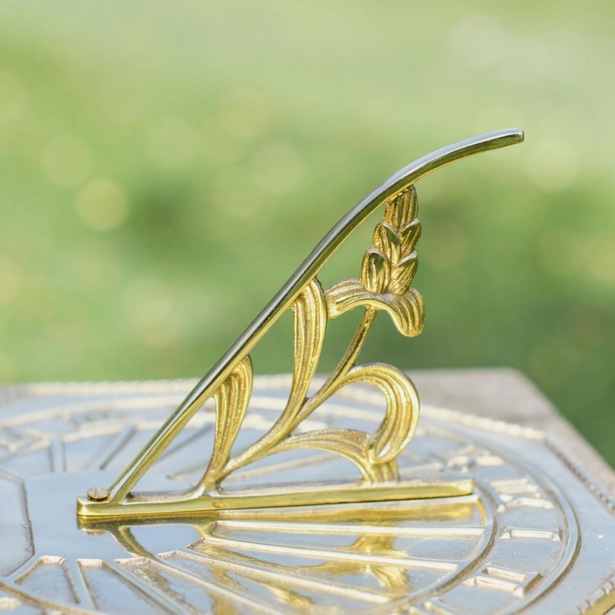 Close-Up of Ornate Gnomon on Polished Brass Sundial