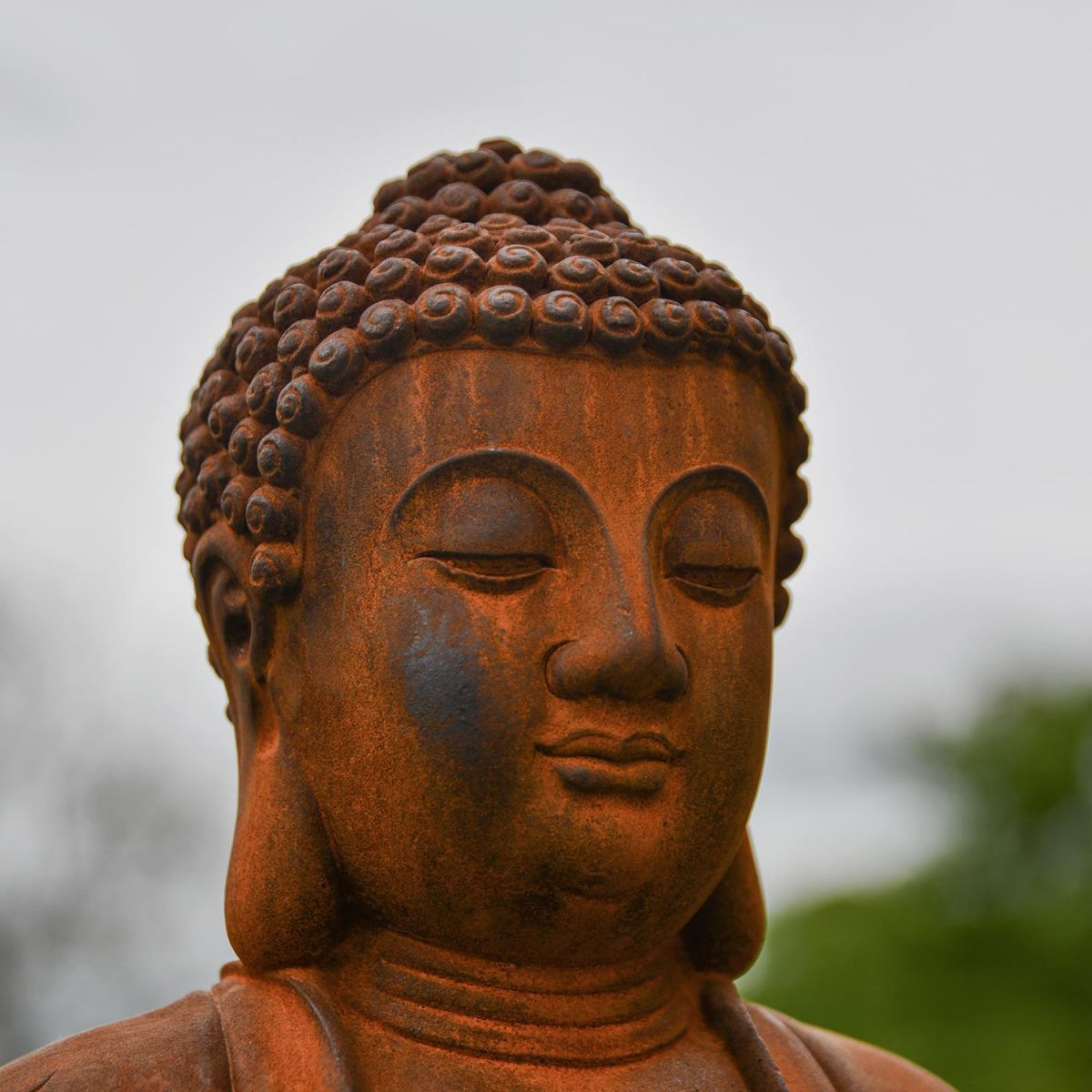 Close-up of the Face on the Rustic Cast Iron Buddha Sculpture