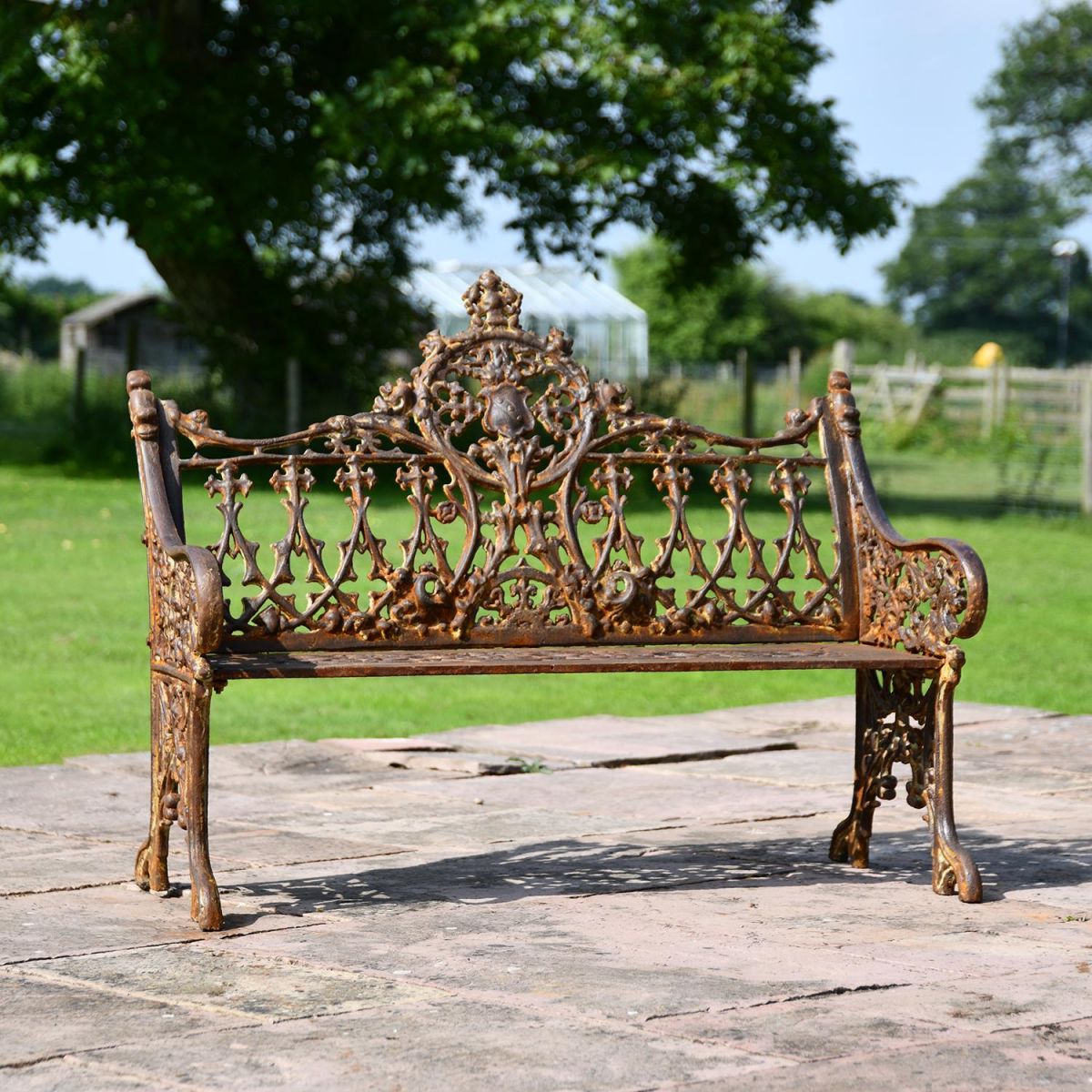 Rustic Cast Iron Gothic Two Seat Bench in Use on a Garden Patio