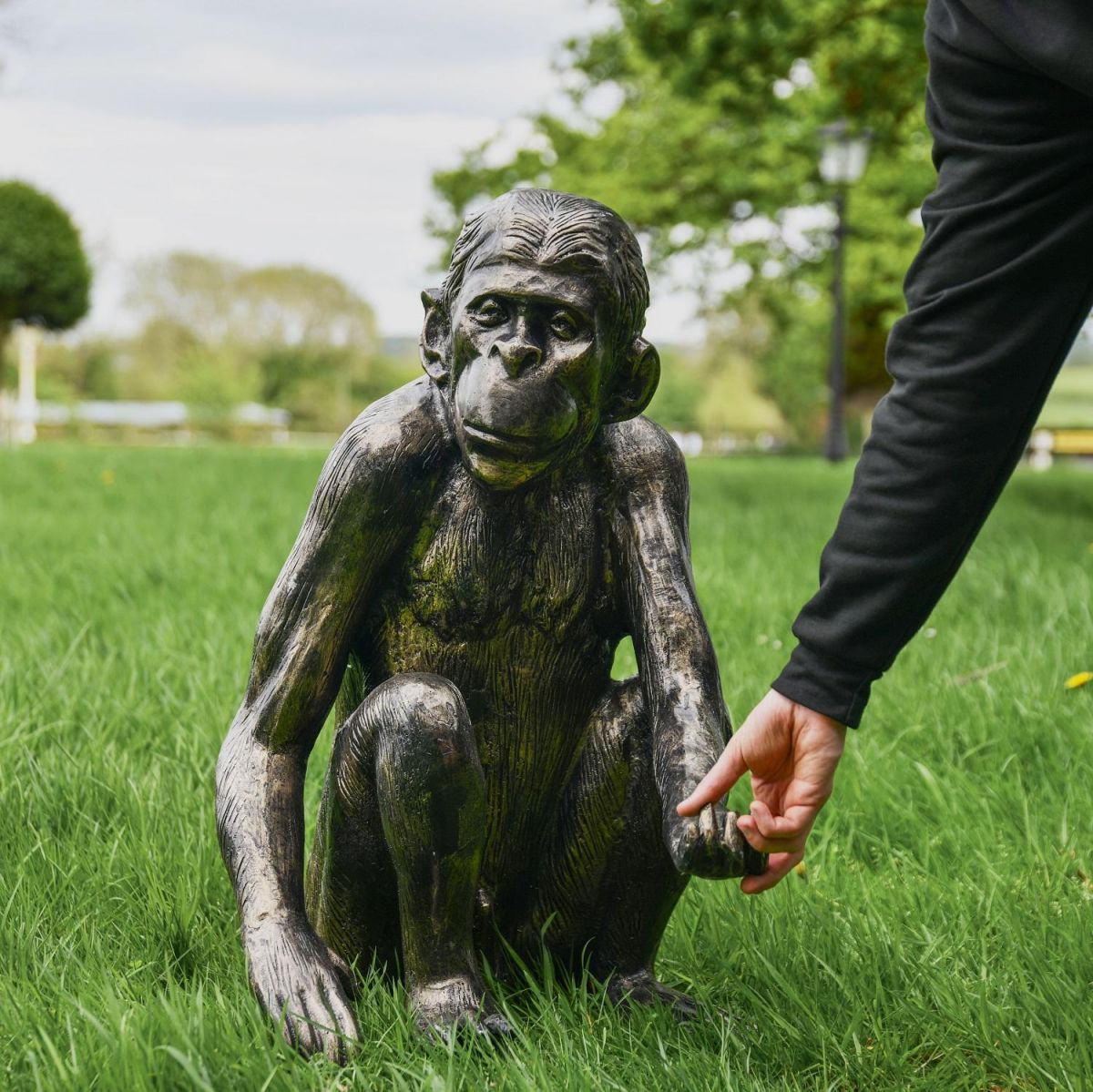 Brushed Gold Sitting Monkey Sculpture with Male Hand for Scale 