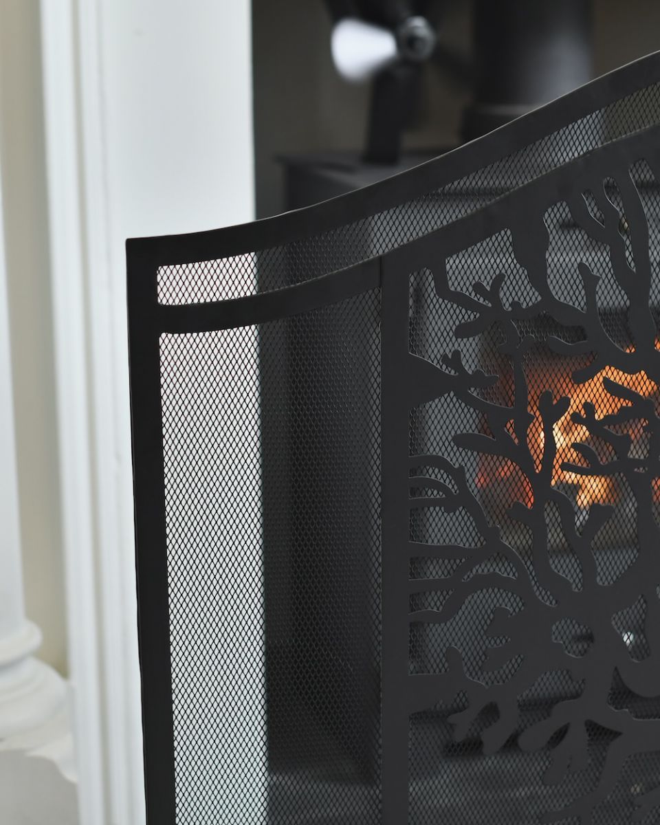 Close up of iron detailing and mesh panelling on decorative black fire guard