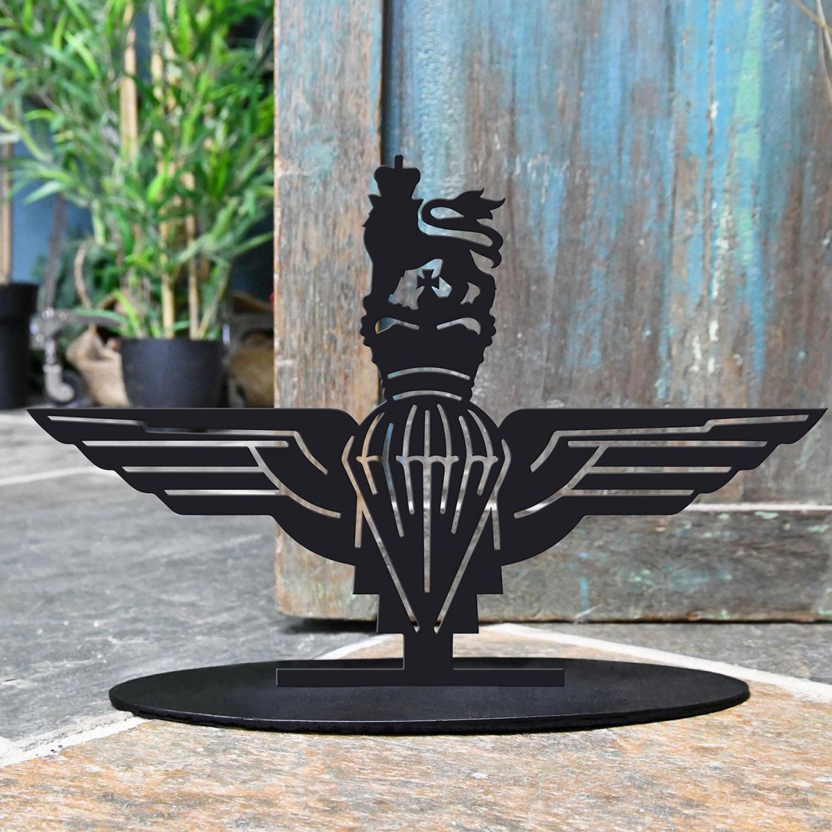 British Parachute Regiment Iron Door Stop Next to a Rustic Blue Door