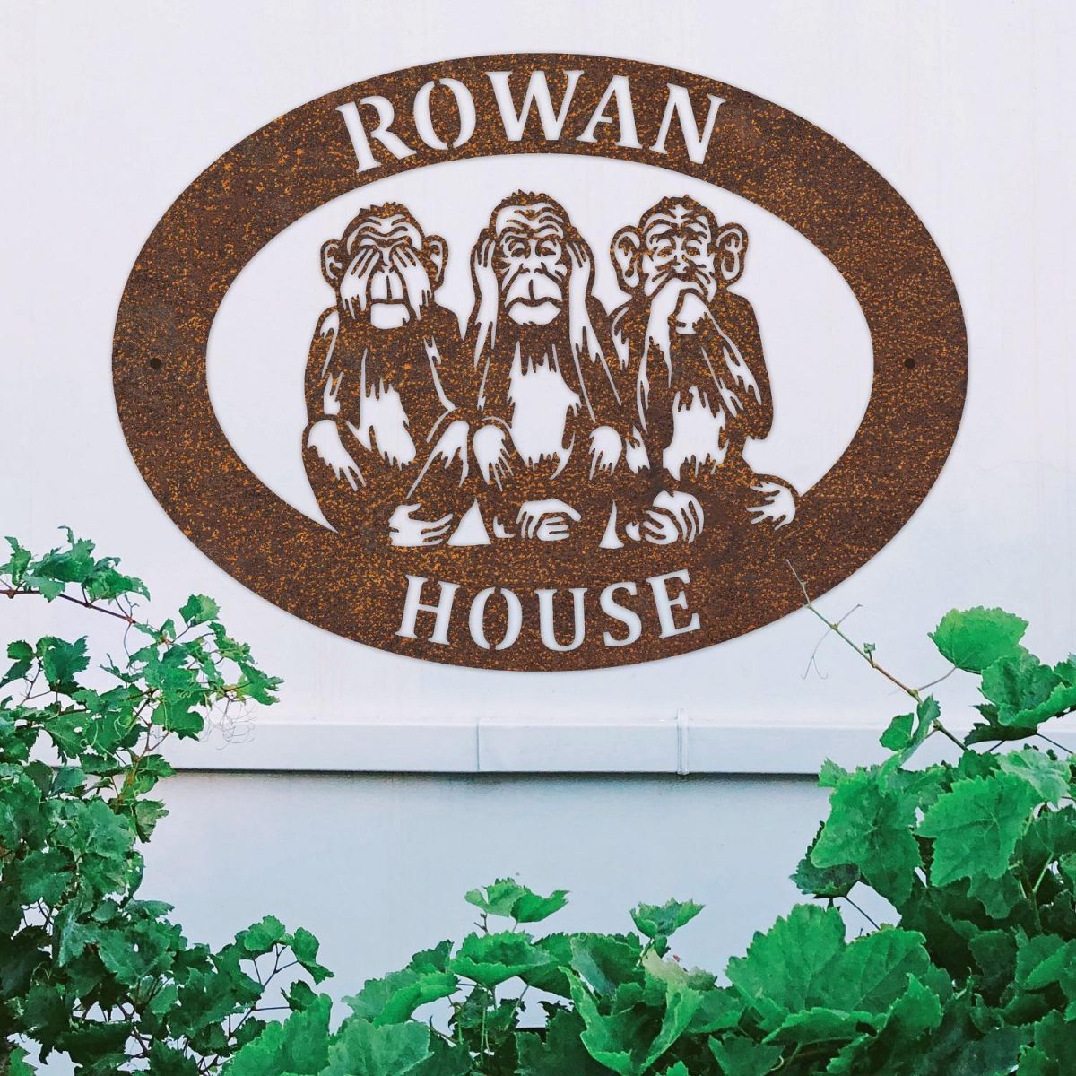 "See No Evil, Hear No Evil, Speak No Evil" Iron Oval House Sign on a White Wall