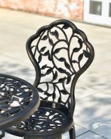 Close up of ornate chair backrest detail on cast aluminium garden furniture set