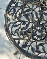 Close up of intricate vine detailing on outdoor two seater table and chairs set