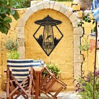 "I Want to Believe" Alien Wall Art on a Yellow Brick Wall