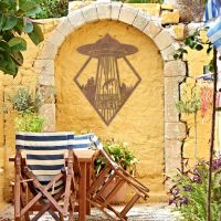 "I Want to Believe" Alien Wall Art on a Yellow Brick Wall