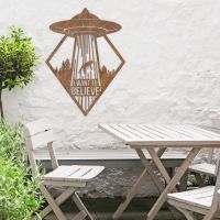 "I Want to Believe" Alien Wall Art in Situ by a Wooden Table Set in the Garden