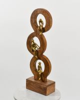 Angled view of cast aluminium and mango wood gold interior ornament