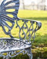 Close Up Of Antique Silver Butterfly Design Two Seater Bench Arm Rests
