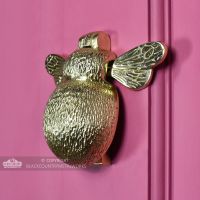 Polished brass bumblebee door knocker on grey door
