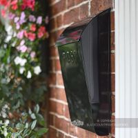 Side view of black newspaper holder & post box