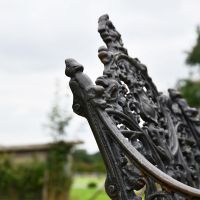 Side view of Aged Black Cast Iron Bench