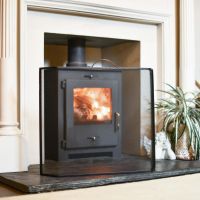 Black Contemporary Curved Fire Guard with Handle In A Fireplace Setting