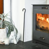 Black Hooked Fireside Poker In A Fire Place Setting